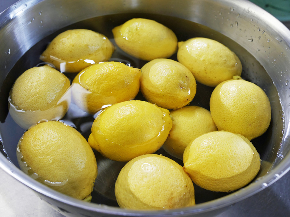 ぬるま湯とたわしでレモンを洗う